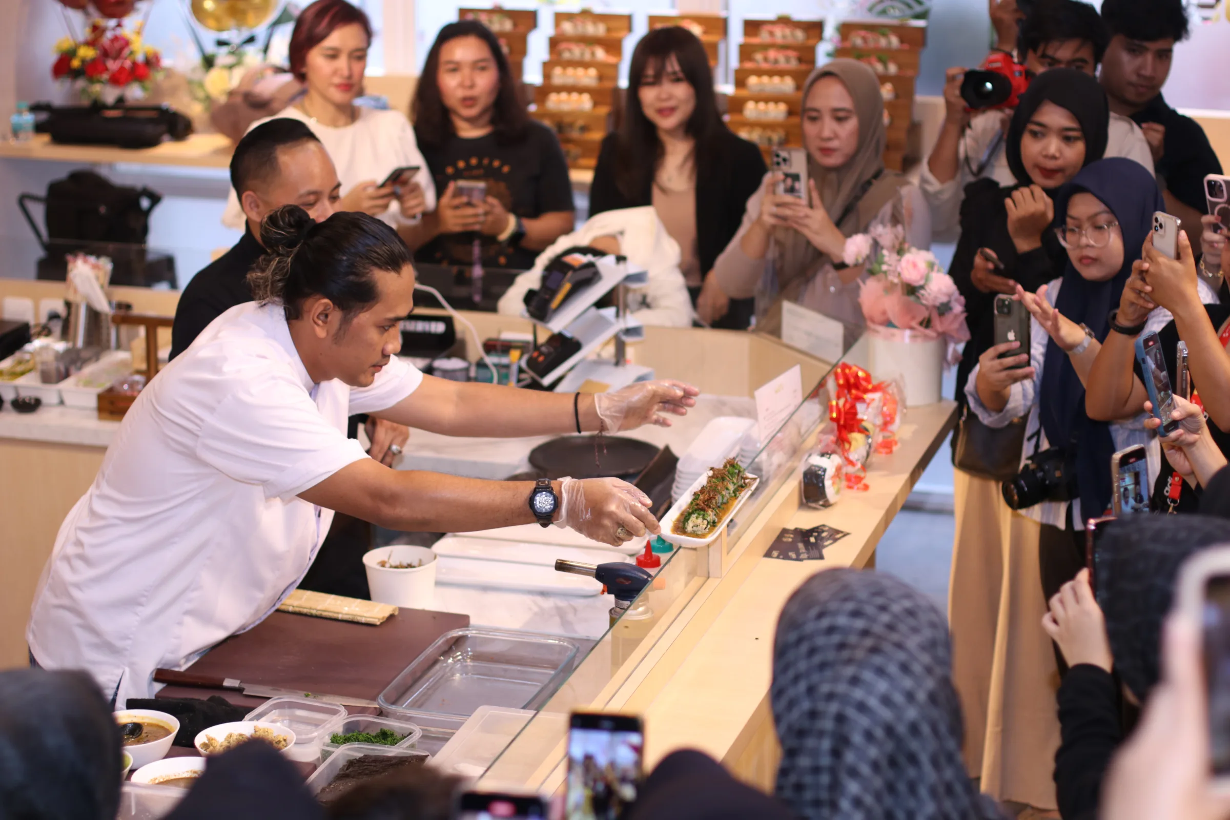 Chef Fahmi presenting sushi during a live event
